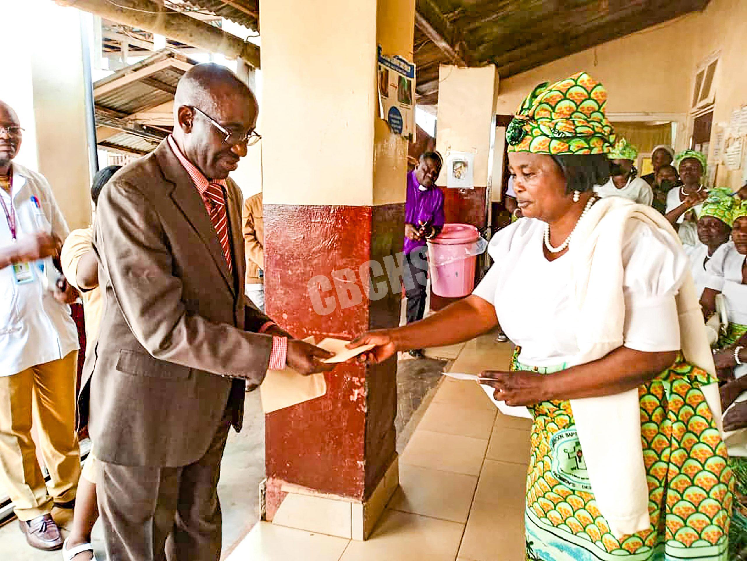 Ndu Field Women handing an envelope of support to theSenior Administrator BBH