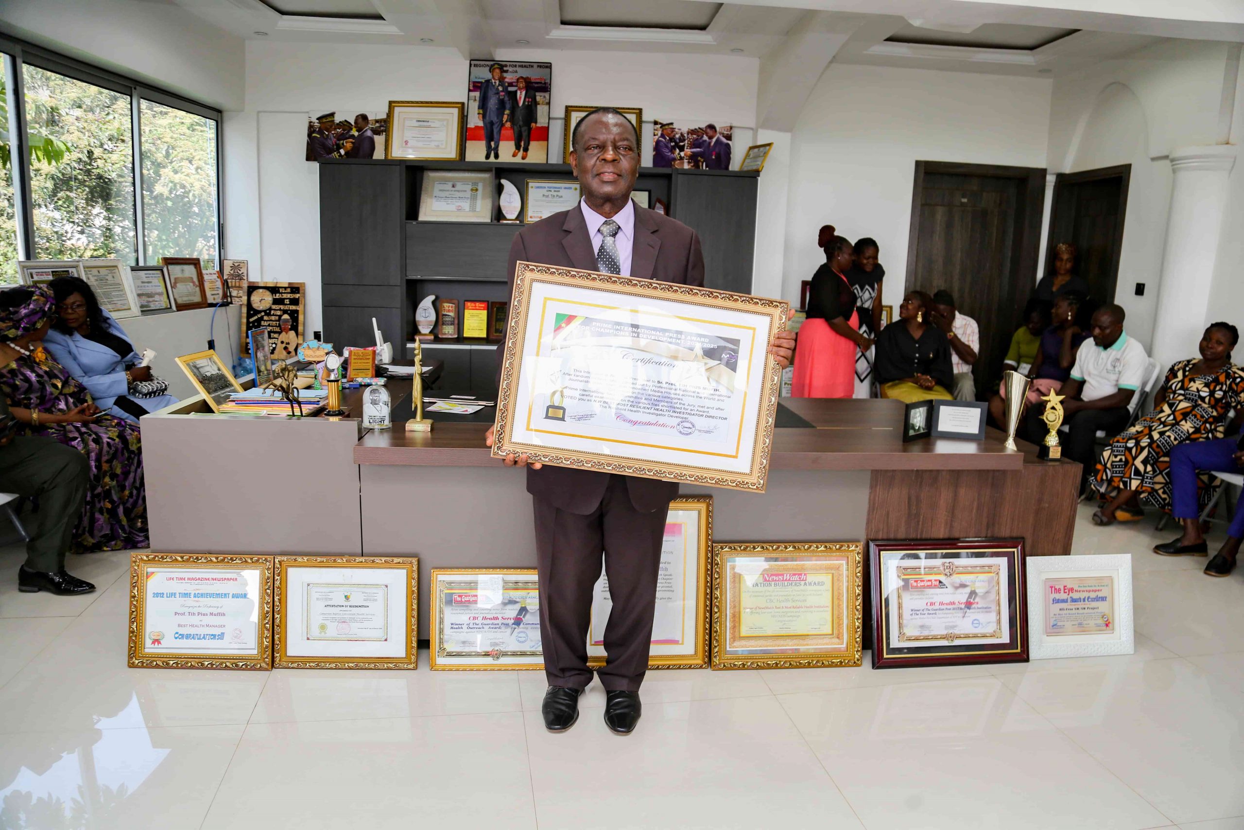 Prof. Tih brandishing award from Prime Media International & My Media Prime TV