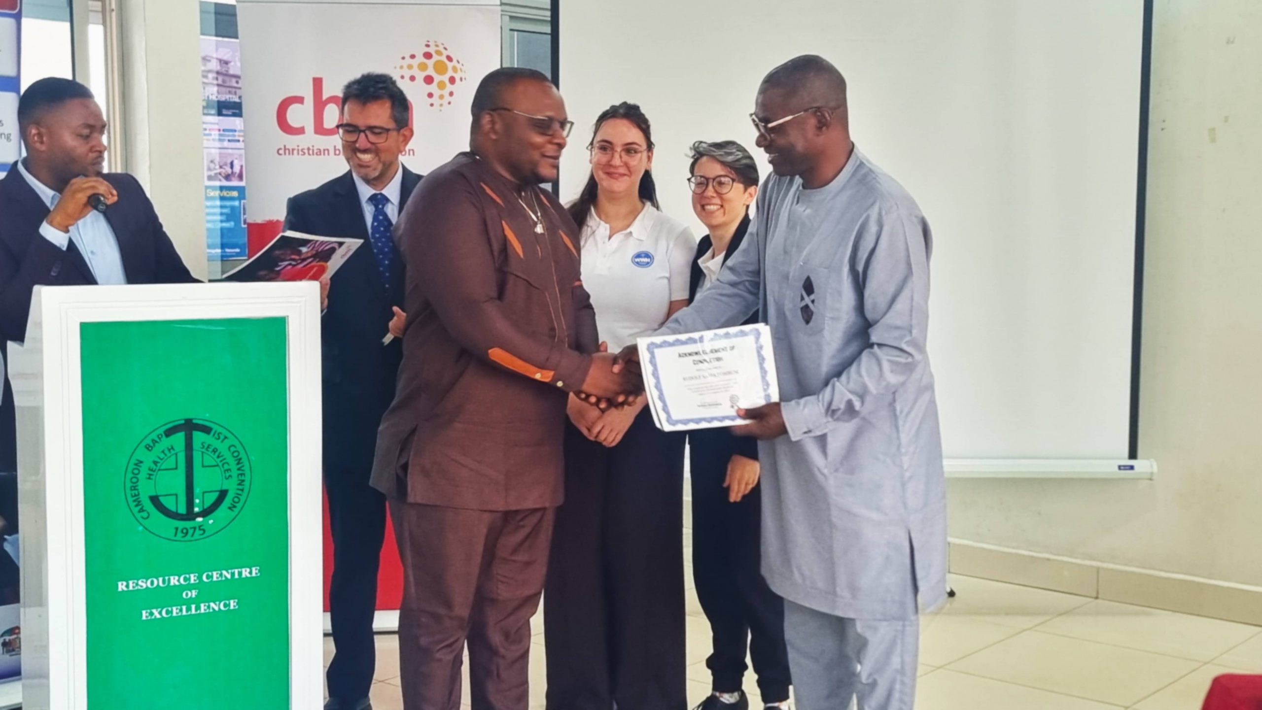CBM Country Director handing end of course attestation to trainees