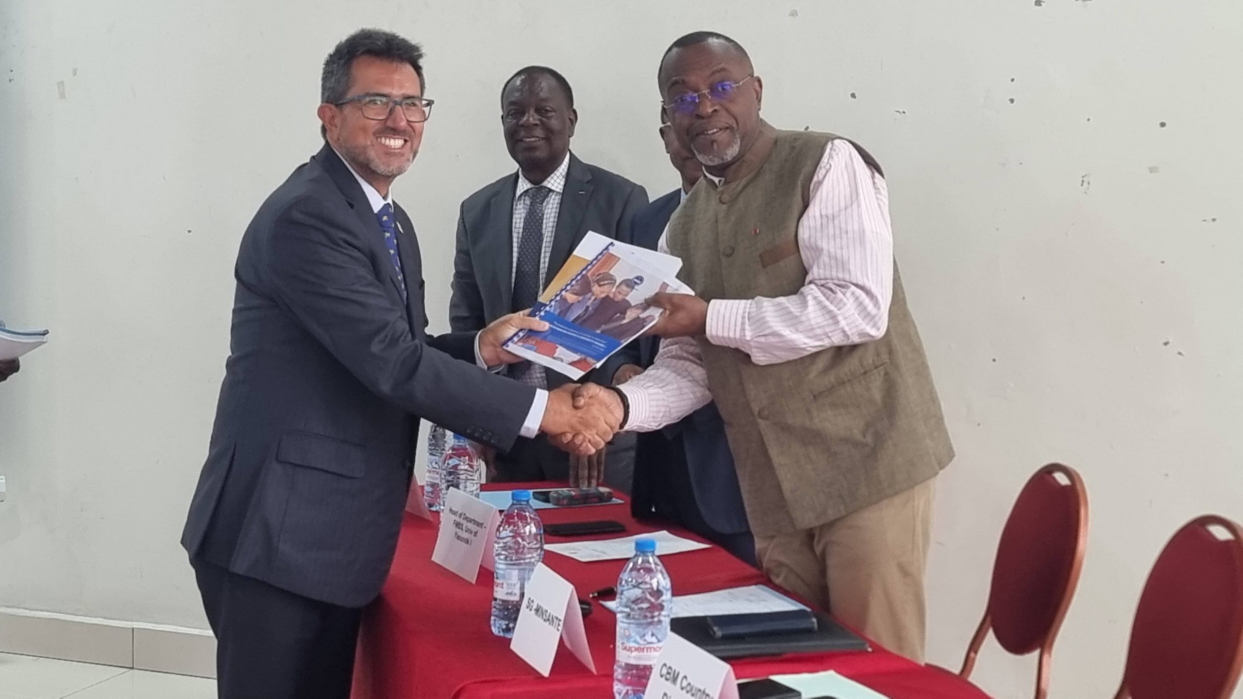Dr. Diego handing a copy of the audiology technician curriculum and training manuals to the SG of MoH