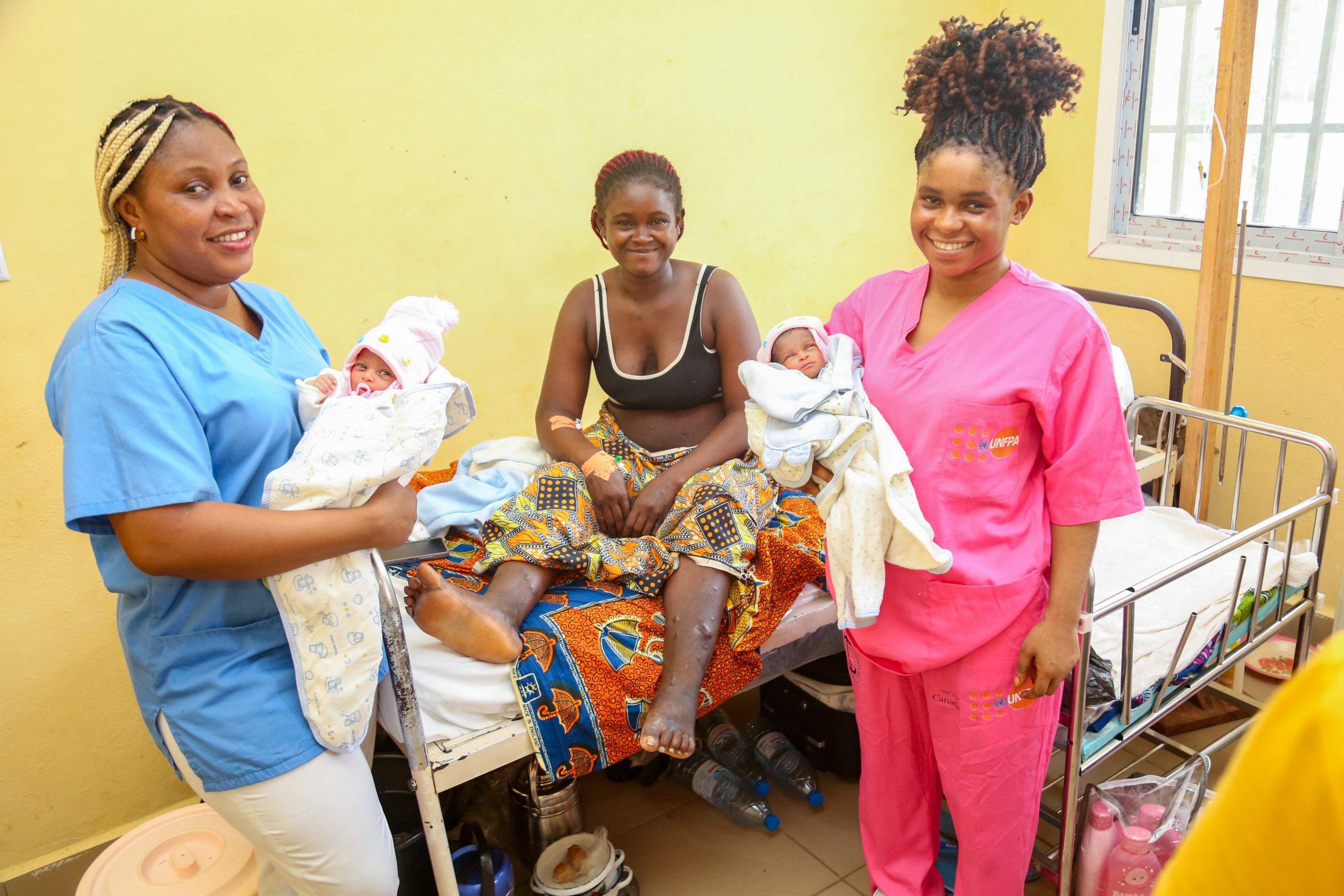 happy young mother celebrates her twin babies with the midwives