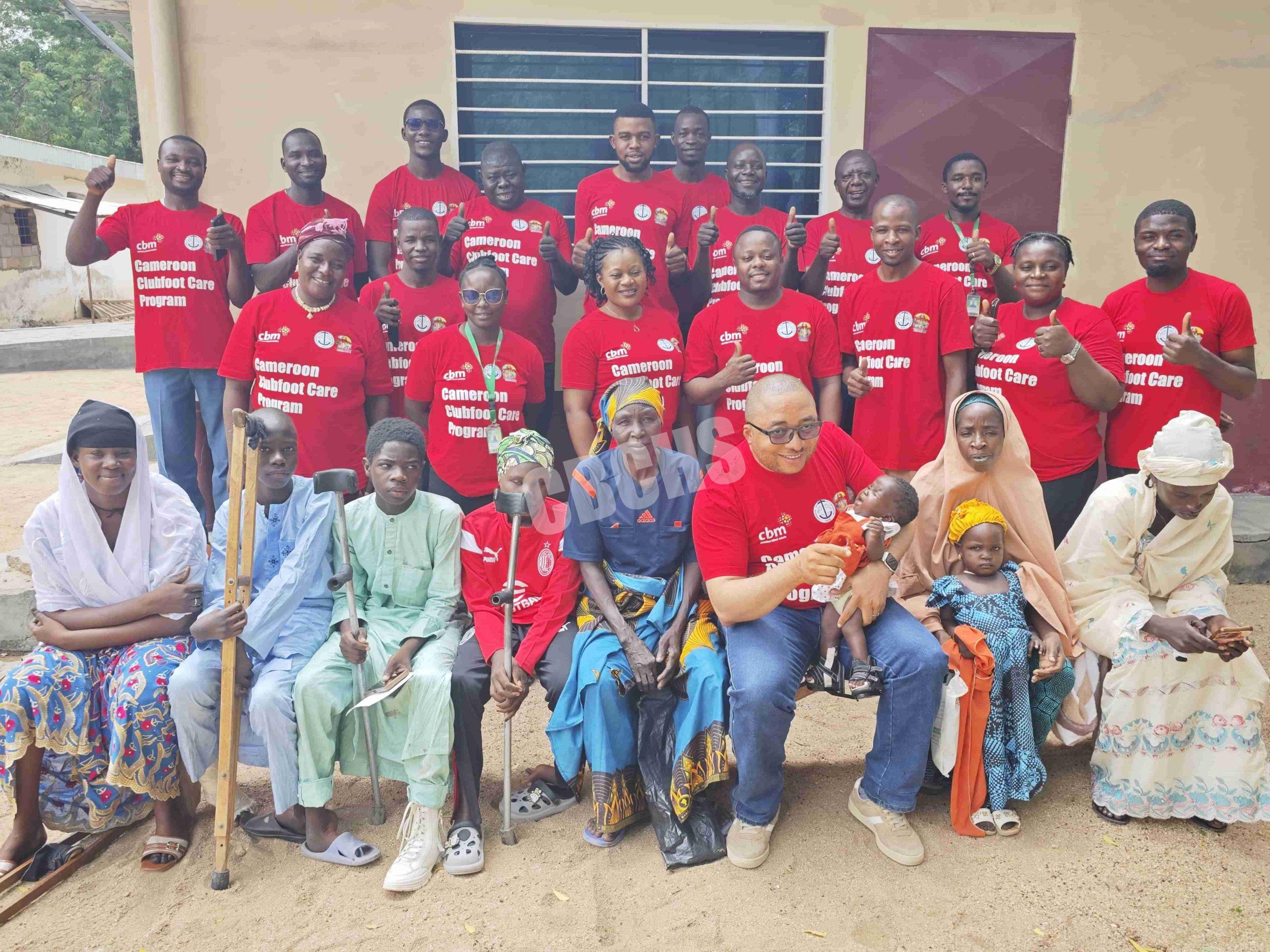 Cameroon Clubfoot Care Program Manager (sitting with baby) with parents and children undergoing clubfoot treatment in Marouateam, healthcare personnel, and some children receiving treatment