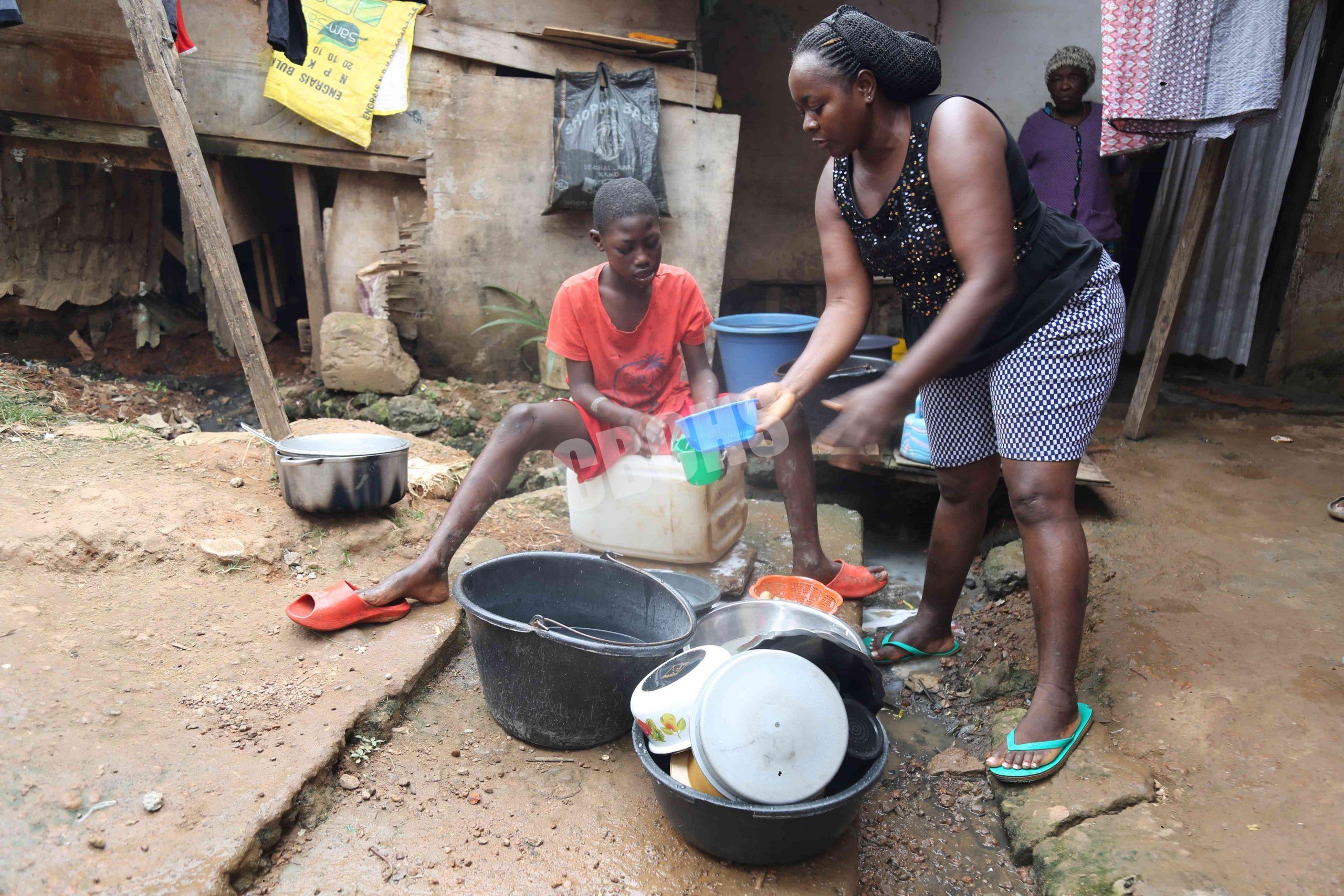 Cherif enjoys washing dishes, guided patiently by his neighbor—finding joy and purpose in helping with daily chores like washing and sweeping.